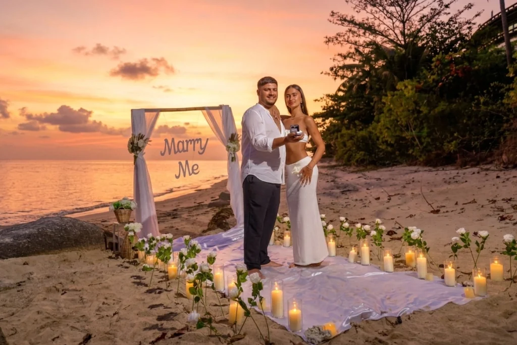 Luxury marriage proposal on the beach in Koh Phangan at sunset, romantic candlelit pathway leading to elegant beachfront setup, couple standing together during intimate proposal moment, tropical Thailand beach atmosphere, soft golden sunset light, luxury boho proposal styling with flowers and lanterns, calm ocean background, destination engagement experience in Koh Phangan, cinematic and emotional beach proposal, premium travel romance aesthetic, realistic luxury setup in Thailand
